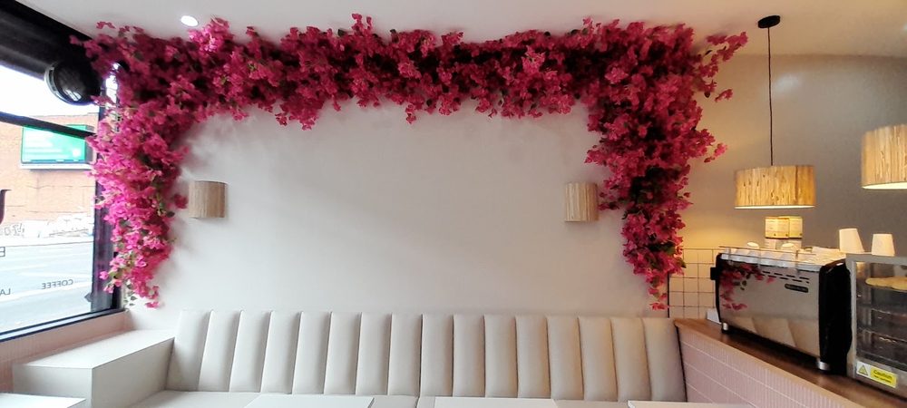 Banquette seating under the bougainvillea arch, warm wall lights