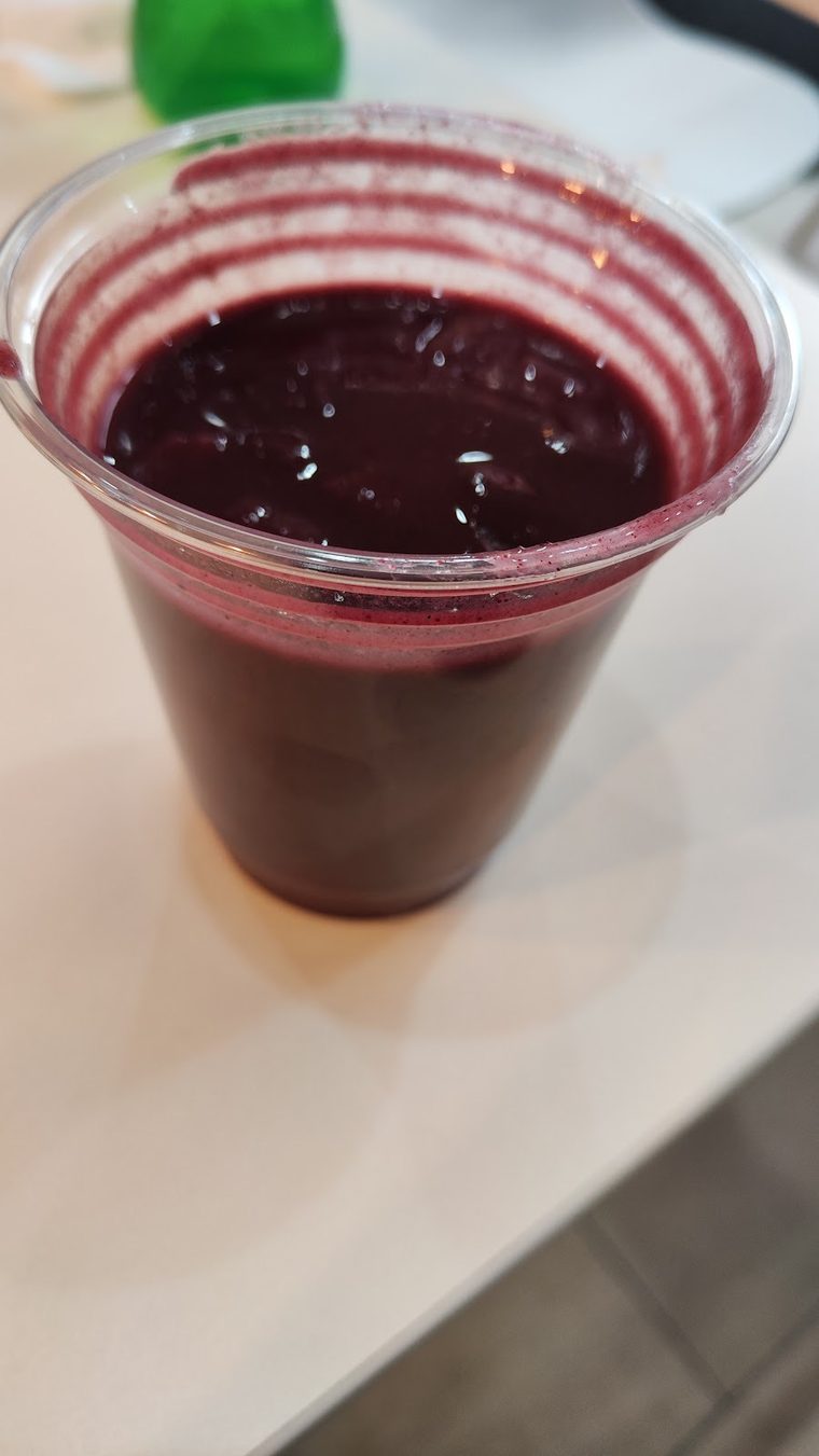 Purple-red fruit juice in a takeaway cup